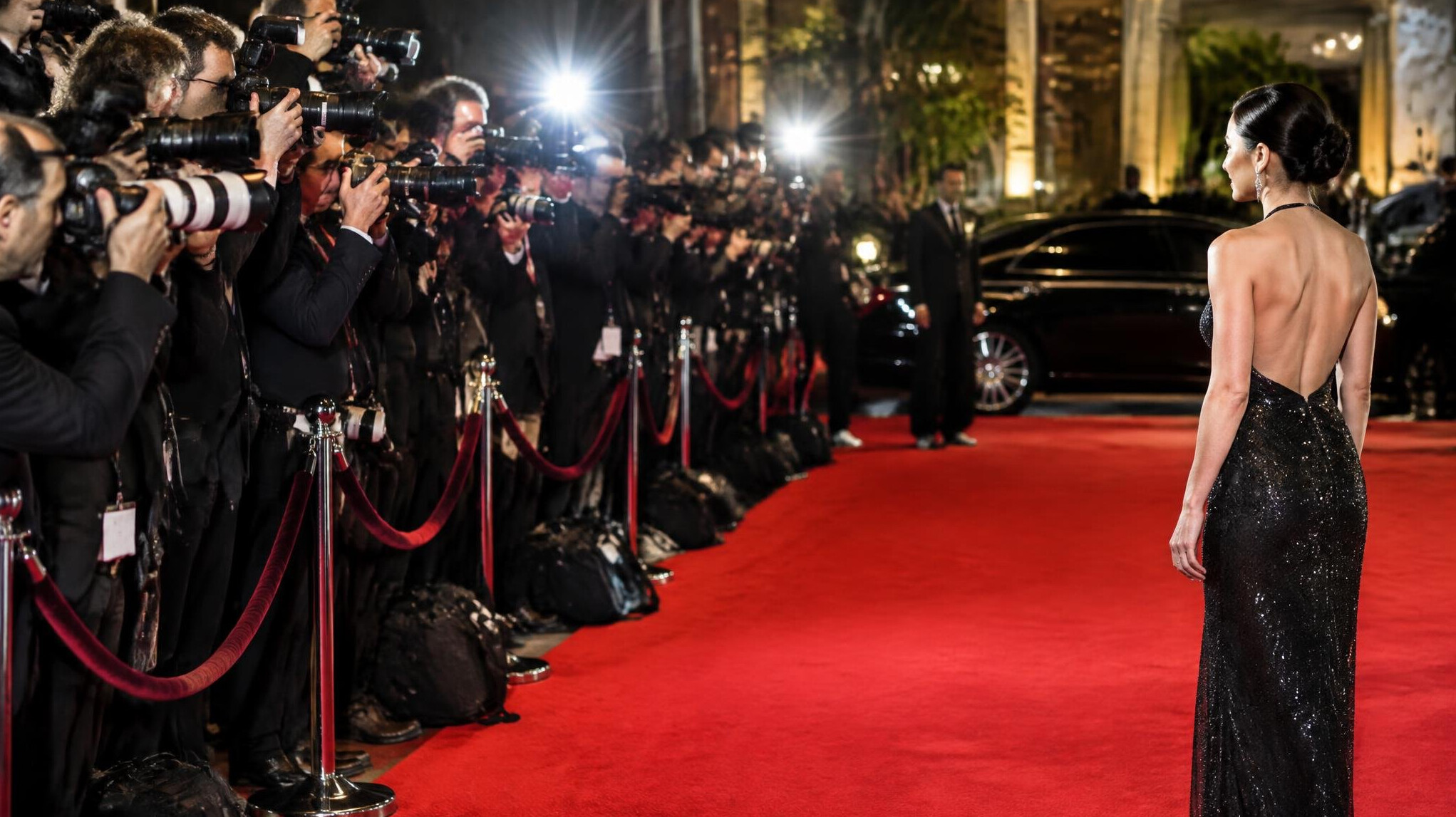 Photographers lined up capturing a celebrity arrival